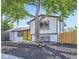 Charming home exterior with a modern design, bright yellow door, and mature landscaping at 1880 E 81St Pl, Denver, CO 80229