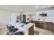 Open concept kitchen with stainless appliances, quartz countertops, island cooktop, and a breakfast bar at 1880 E 81St Pl, Denver, CO 80229