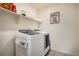 Bright laundry room featuring new front-load washer and dryer with storage shelves above at 760 N Allium St, Watkins, CO 80137