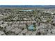 Expansive aerial view featuring a lake, lush greenery, and mountain views, offering a serene neighborhood setting at 5875 W Asbury Pl, Lakewood, CO 80227