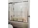 Bathroom featuring a tiled shower with glass doors and modern fixtures at 5875 W Asbury Pl, Lakewood, CO 80227