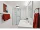 Bright bathroom featuring a glass shower stall, a vanity with a sink, and stylish red decor at 5875 W Asbury Pl, Lakewood, CO 80227