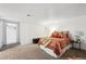 Spacious bedroom featuring neutral carpet, and an open doorway to the bathroom for added convenience at 5875 W Asbury Pl, Lakewood, CO 80227