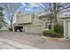 Charming townhome with a two-car garage, set against a blue sky backdrop, with mature trees nearby at 5875 W Asbury Pl, Lakewood, CO 80227