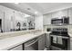 Bright kitchen with white counters, stainless appliances, grey cabinetry, and view to dining area at 5875 W Asbury Pl, Lakewood, CO 80227