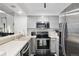Kitchen features white countertops, stainless steel appliances, grey cabinets, and view to dining room at 5875 W Asbury Pl, Lakewood, CO 80227