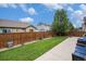 Spacious backyard featuring a well-maintained lawn, fence, and concrete patio at 11511 E 118Th Ave, Commerce City, CO 80640