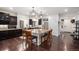 Kitchen featuring an island with seating, stainless steel appliances, dark cabinets, and hardwood floors at 11511 E 118Th Ave, Commerce City, CO 80640