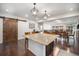 Open kitchen view featuring a center island with seating, modern pendant lighting and barn door at 11511 E 118Th Ave, Commerce City, CO 80640