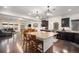 Open kitchen area featuring a center island with seating, stainless steel appliances, and hardwood floors at 11511 E 118Th Ave, Commerce City, CO 80640