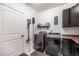 Well-equipped laundry room with modern washer, dryer, storage cabinets and access to utilities at 11511 E 118Th Ave, Commerce City, CO 80640
