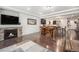 Open-concept living area with a fireplace, hardwood flooring, and a dining table and kitchen area at 11511 E 118Th Ave, Commerce City, CO 80640