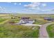 Expansive home with a three-car garage nestled in a vast, open landscape with a long drive at 527 Antelope E Dr, Bennett, CO 80102