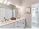 Bathroom with double sinks, white cabinets, and granite counters with an adjacent shower at 527 Antelope E Dr, Bennett, CO 80102