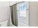 Bright bathroom features a window, tiled walls, and a shower with a curtain at 527 Antelope E Dr, Bennett, CO 80102