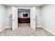 Neutral walls, carpeted floors and a partial view of a large sectional sofa through open double doors at 527 Antelope E Dr, Bennett, CO 80102