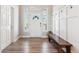 Inviting entryway featuring a coat rack, wooden bench, and sidelight windows flanking the front door at 527 Antelope E Dr, Bennett, CO 80102