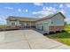 Charming home featuring stone accents, three-car garage, covered porch, and a spacious concrete driveway at 527 Antelope E Dr, Bennett, CO 80102