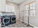 Well-equipped laundry room with modern washer/dryer and decorative patterned flooring at 527 Antelope E Dr, Bennett, CO 80102