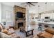 Open-concept living room showcasing a stone fireplace, comfortable seating, and a view of the kitchen and dining area at 527 Antelope E Dr, Bennett, CO 80102