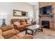 Cozy living room featuring a stone fireplace, comfortable seating, and a large mirror enhancing the natural light at 527 Antelope E Dr, Bennett, CO 80102
