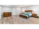 This main bedroom features wood furniture, light walls and wood look flooring at 527 Antelope E Dr, Bennett, CO 80102