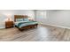 This main bedroom features wood furniture, light walls and wood look flooring at 527 Antelope E Dr, Bennett, CO 80102