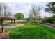 Expansive backyard features a large lawn, mature trees, and a covered patio, perfect for outdoor enjoyment at 11310 W Center Ave, Lakewood, CO 80226