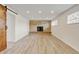 Spacious basement boasts wood-look floors, recessed lighting, and a brick fireplace feature at 11310 W Center Ave, Lakewood, CO 80226