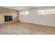 Basement with a brick fireplace, wood-look flooring, and natural light from the windows at 11310 W Center Ave, Lakewood, CO 80226
