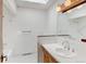 Clean bathroom with a single vanity, a white tiled shower, and a bright skylight at 11310 W Center Ave, Lakewood, CO 80226