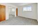 Bedroom featuring new carpet, large windows, and a mirrored sliding closet at 11310 W Center Ave, Lakewood, CO 80226