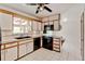Bright kitchen with white cabinets, black appliances, and tile floors offers eat-in space at 11310 W Center Ave, Lakewood, CO 80226