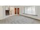 Bright living room with neutral carpet, a large window, and a decorative wood front door at 11310 W Center Ave, Lakewood, CO 80226