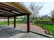 Covered patio with stone and concrete surfaces leading to a lush green yard and well-maintained landscaping at 11310 W Center Ave, Lakewood, CO 80226