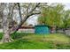 Backyard shed within a fenced area, surrounded by mature trees and a well-maintained lawn, providing practical storage at 11310 W Center Ave, Lakewood, CO 80226