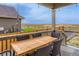 Covered back porch with a wood table and six wicker chairs overlooking the serene landscape at 17786 Olive St, Broomfield, CO 80023