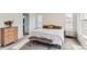 Well-lit bedroom features a large bed, accent bench, and views out of a large window at 17786 Olive St, Broomfield, CO 80023