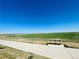 Park bench on a paved walkway with scenic views of rolling green hills and mountain range at 17786 Olive St, Broomfield, CO 80023