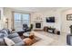 Comfortable living room featuring a plush sectional, stone fireplace, stylish decor, and abundant natural light, perfect for relaxation at 17786 Olive St, Broomfield, CO 80023