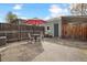 Outdoor patio space with seating and umbrella, surrounded by a wooden fence at 3647 Jason St, Denver, CO 80211
