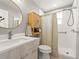 Clean, updated bathroom with modern vanity, round mirror, and tiled shower featuring a shower curtain at 2517 W 44Th Ave, Denver, CO 80211