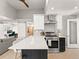 Open kitchen featuring stainless steel appliances, a quartz island, and modern cabinetry with barstool seating at 2517 W 44Th Ave, Denver, CO 80211