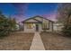 Charming single-story home with a well-manicured lawn and inviting front porch under a beautiful sunset sky at 124 3Rd St, Fort Lupton, CO 80621