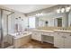 Bright bathroom featuring a soaking tub with shower and dual sink vanity at 9524 E Caley Cir, Englewood, CO 80111