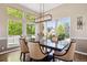 Bright dining room featuring large windows, modern lighting, and a spacious table with seating for six at 9524 E Caley Cir, Englewood, CO 80111