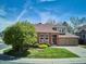 Charming brick home with a well-manicured lawn, mature trees, and a two-car garage at 9524 E Caley Cir, Englewood, CO 80111
