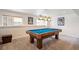 Basement game room with a blue pool table and unique lighting fixture at 9524 E Caley Cir, Englewood, CO 80111
