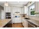 Bright kitchen featuring white cabinets, stainless steel appliances, granite countertops, and hardwood flooring at 9524 E Caley Cir, Englewood, CO 80111