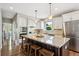 Modern kitchen featuring a large island, stainless steel appliances, and wooden bar stools at 9524 E Caley Cir, Englewood, CO 80111